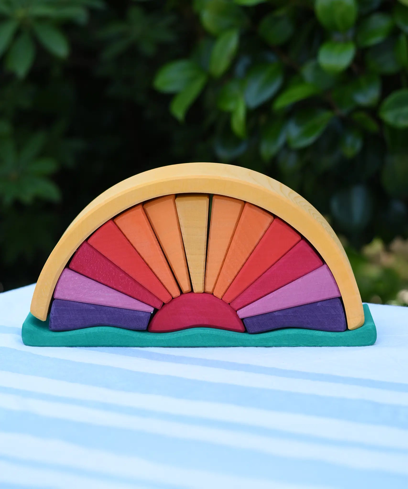 Glückskäfer wooden stacking sunray arch in yellow purple placed on a table outdoors. 