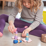 A close up of a child playing with the Grapat 12 Magos wooden peg dolls. These wooden toys are part of a wide range of open ended toys available at Babipur.  