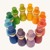 Grapat 12 Magos wooden peg dolls with top hats in a rainbow of 12 colours placed in a circle. These wooden toys are part of a wide range of open ended toys available at Babipur.  