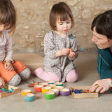 Two children and an adult playing with the Grapat 12 Rainbow Wooden Sorting Bowls. These Grapat bowls are part of a big range of open ended wooden toys available at Babipur. 