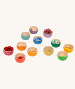 Grapat 12 Rainbow Wooden Sorting Bowls filled with loose parts and natural pieces in matching colours. These Grapat bowls are part of a big range of open ended wooden toys available at Babipur. 