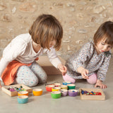 Two children kneeling down playing with the Grapat 12 Rainbow Wooden Sorting Bowls. These Grapat bowls are part of a big range of open ended wooden toys available at Babipur. 