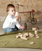 A child playing with the pieces from the Grapat 20 Element Treasure Basket. A mix of wooden toys for little hands to explore. These wooden toys are part of a wide range of open ended toys available at Babipur.  