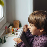 Child looking on at a set up of small wooden toys included in the Grapat 2026 advent calendar available at Babipur.