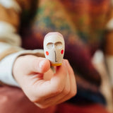 Close up of a wooden face piece in a child's hand from one of the gift boxes included in the Grapat 2026 advent calendar available at Babipur.