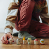 Child's hand lining up wooden face pieces  included in the Grapat 2026 advent calendar available at Babipur.