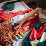 Child's hand reaching for wooden peg dolls from one of the gifts included in the Grapat 2026 advent calendar available at Babipur.
