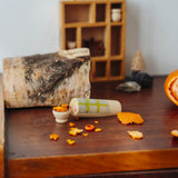 Wooden Tio log character with tangerine peel pieces placed ina  small wooden bowl. One of the gifts included in the Grapat 2026 advent calendar available at Babipur.