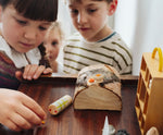 Children playing with the wooden Tio log character. One of the gifts included in the Grapat 2026 advent calendar available at Babipur.