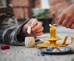 Child placing a piece of rolled up paper into a decorated wooden pot from one of the gifts included in the Grapat 2026 advent calendar available at Babipur. 