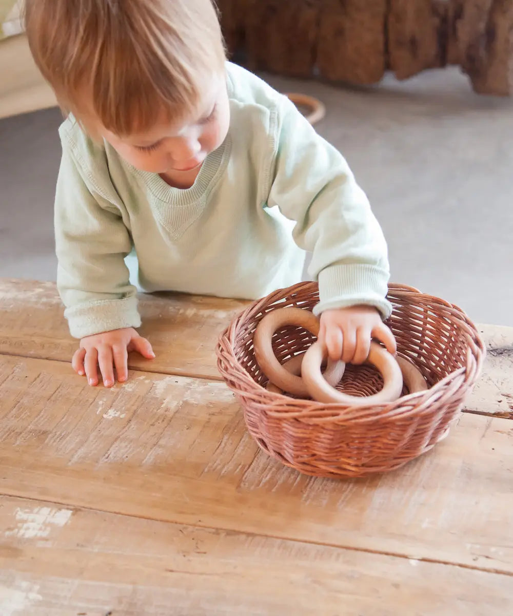 Child playing with Grapat 3 little wooden hoops loose parts toy.