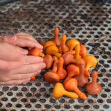 A hand reaching for the Grapat 36x Mandala Pumpkins in  shades of orange. 