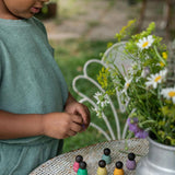 Close up of young child playing with the Grapat baby nin peg doll toys on a white metal table