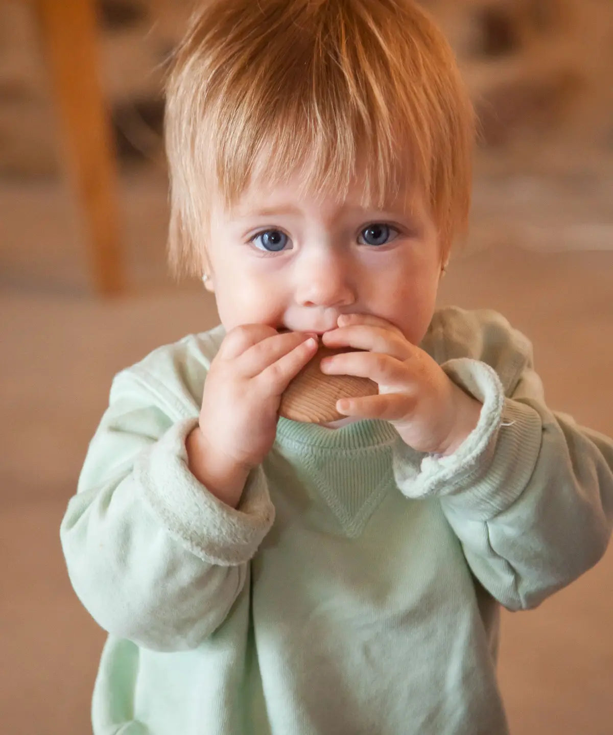 A child with a Grapat wooden loose disk in the mouth
