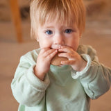 A child with a Grapat wooden loose disk in the mouth