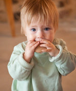 A child with a Grapat wooden loose disk in the mouth