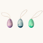 Grapat Handmade Wooden Aurora Eggs Cold Colours Easter Decorations. One egg is purple, one is blue and one is green. They are all hand decorated with floral, leafy details. 