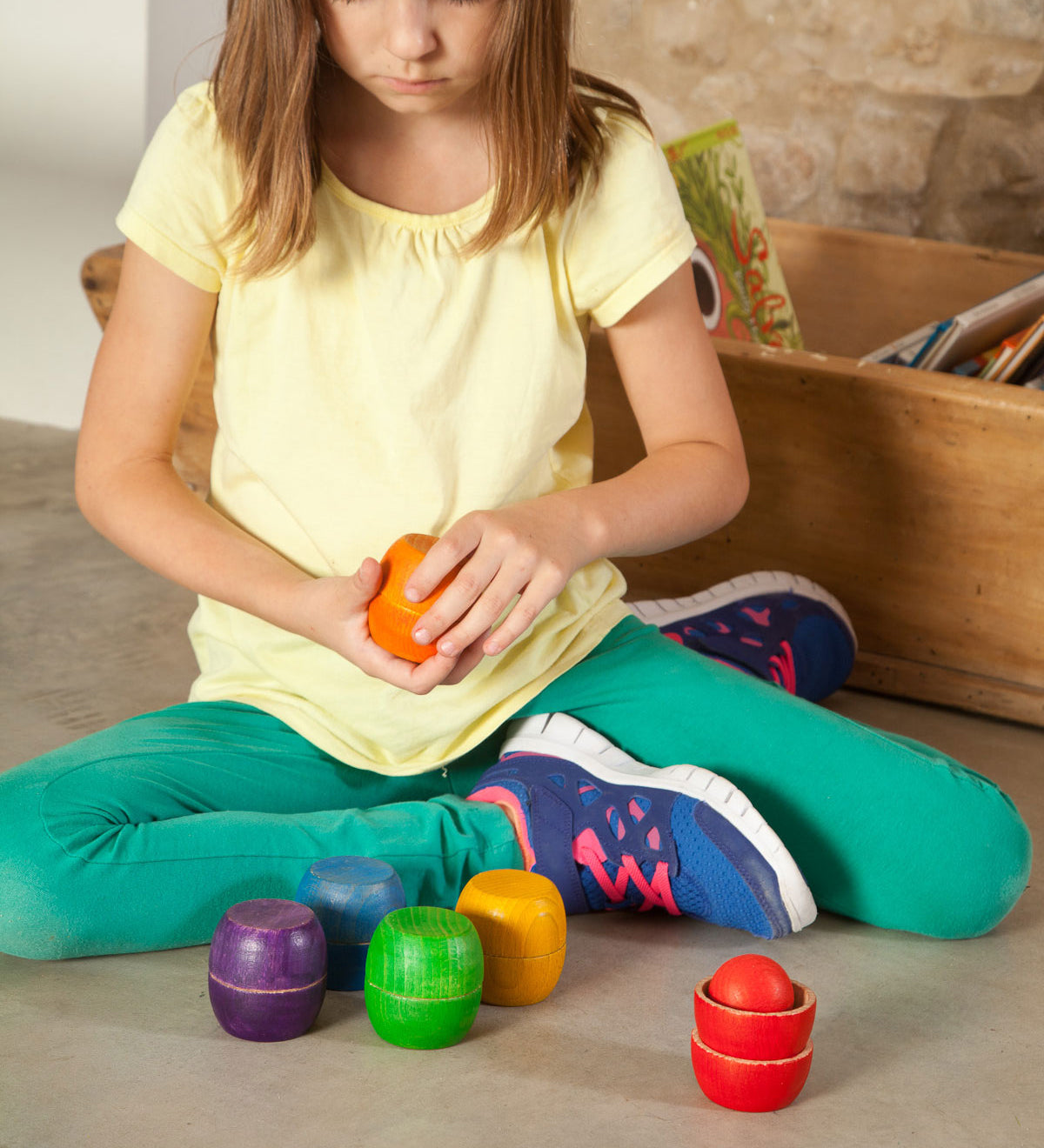 A child playing with the Grapat Bowls & Balls Set. A set of 5 wooden balls and 12 wooden balls. These are perfect for colour matching activities. These wooden toys are part of a wide range of open ended toys available at Babipur.  