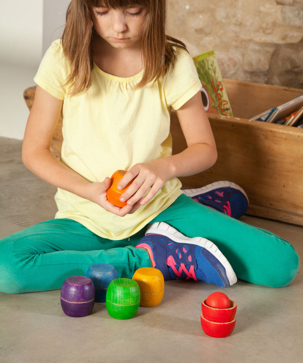 A child playing with the Grapat Bowls & Balls Set. A set of 5 wooden balls and 12 wooden balls. These are perfect for colour matching activities. These wooden toys are part of a wide range of open ended toys available at Babipur.  