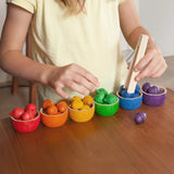 A child playing with the Grapat Wooden Toy Bowls and  Acorns Set. A set of 6 coloured bowls with wooden acorn shapes in matching pieces. 