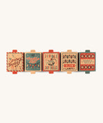 a row of the cardboard boxes for the different Grapat christmas decoration sets on a cream background