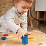 Child holding a Grapat handcrafted wooden cup with green lid on a table
