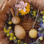 Grapat handmade Wooden Easter Decorations Hop bunny and Peep chick. The decorations have been placed in a round wicker basket with flowers.
