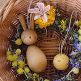 Grapat handmade Wooden Easter Decorations Hop bunny and Peep chick. The decorations have been placed in a round wicker basket with flowers.