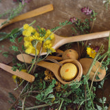 Grapat handmade Wooden Easter Decorations Hop bunny and Peep chick. The chicks in a small wooden spoon, the bunny can be seen underneath the spoon with flowers around them. 