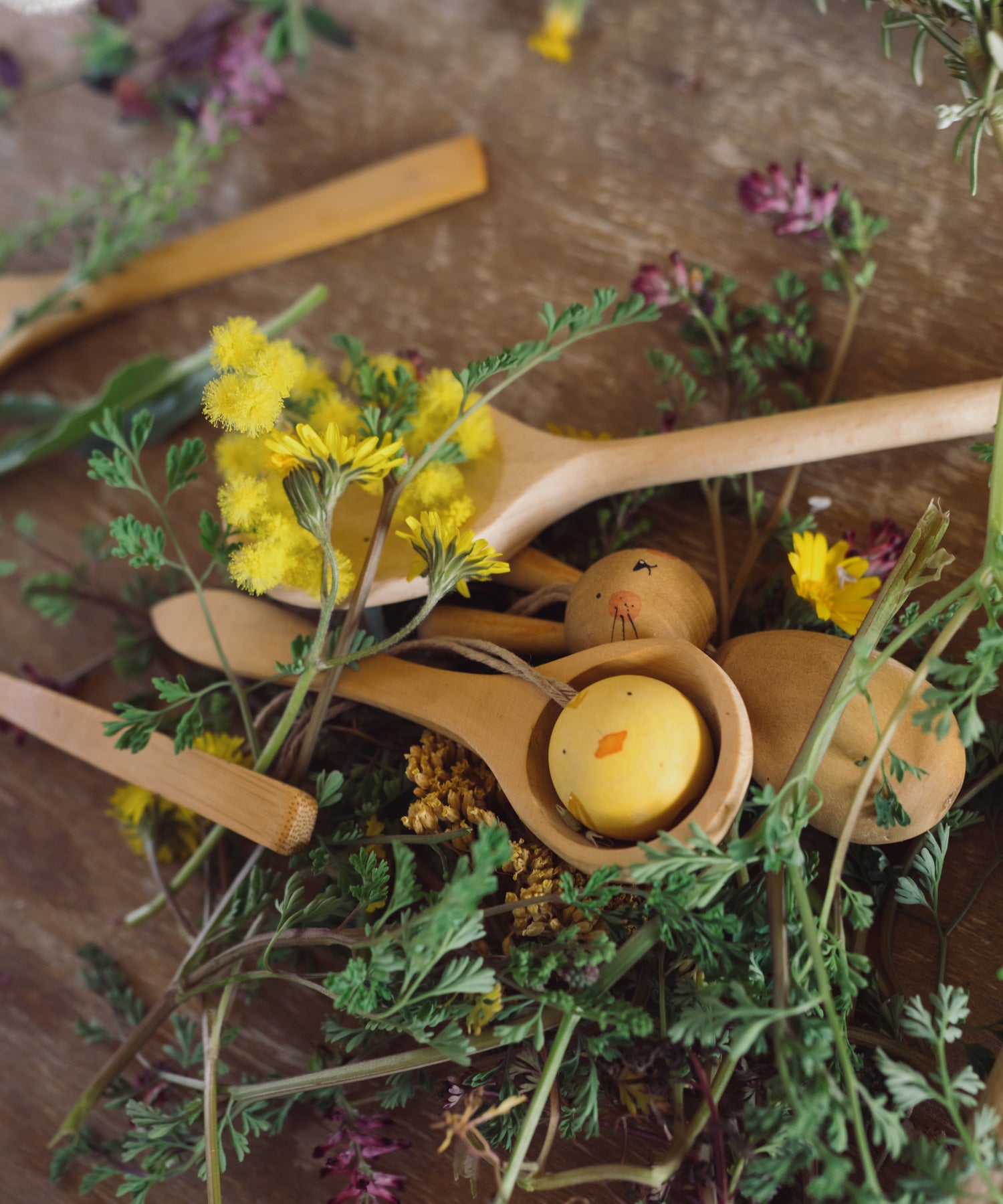 Grapat handmade Wooden Easter Decorations Hop bunny and Peep chick. The chicks in a small wooden spoon, the bunny can be seen underneath the spoon with flowers around them. 