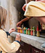 Grapat Fancy Nins Play Set. A set of 12 colourful wooden peg dolls with removable hats. These wooden peg doll toys are part of a wide range of open ended toys available at Babipur. 