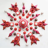 A mandala flatlay made from different Grapat wooden loose pieces in red, white and brown