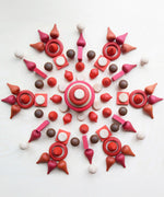 A mandala flatlay made from different Grapat wooden loose pieces in red, white and brown