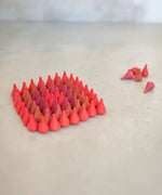 Individual Grapat wooden fire mandala droplet shaped pieces sorted in a diamond shape