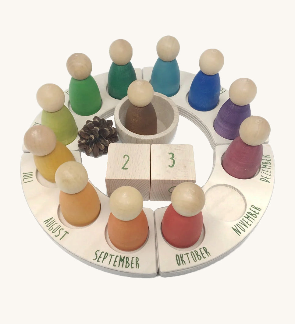 Grapat German Perpetual Calendar showing 12 nin peg dolls a display ring  and two cubes in the centre to mark the day