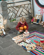 Young boy crouched down opening the lid of the Grapat Waldorf permanence box