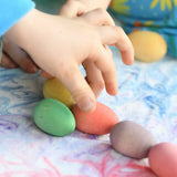 Children's hand picking up the Grapat Happy Eggs wooden toys.