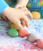 Children's hand picking up the Grapat Happy Eggs wooden toys.