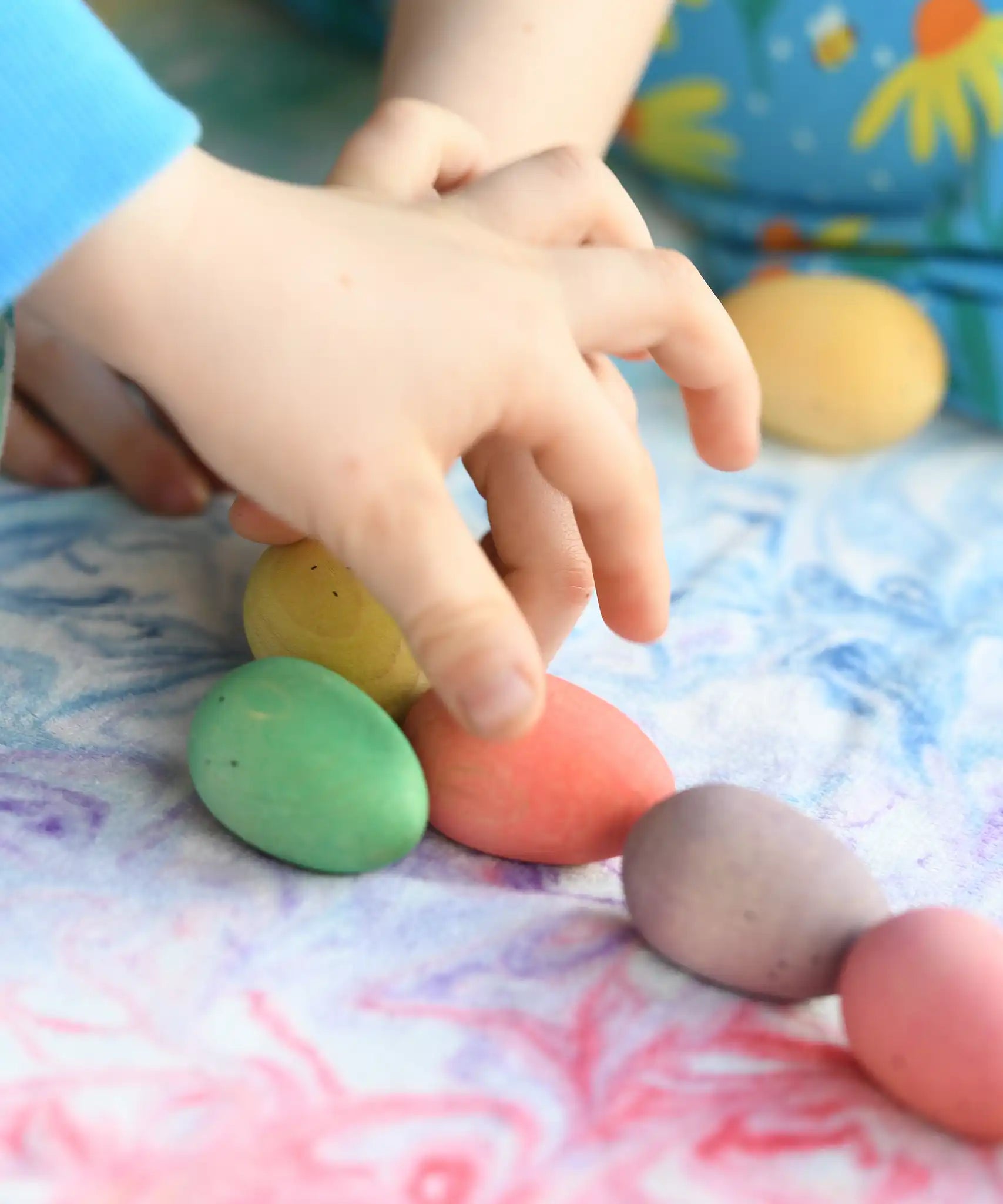 Children's hand picking up the Grapat Happy Eggs wooden toys.