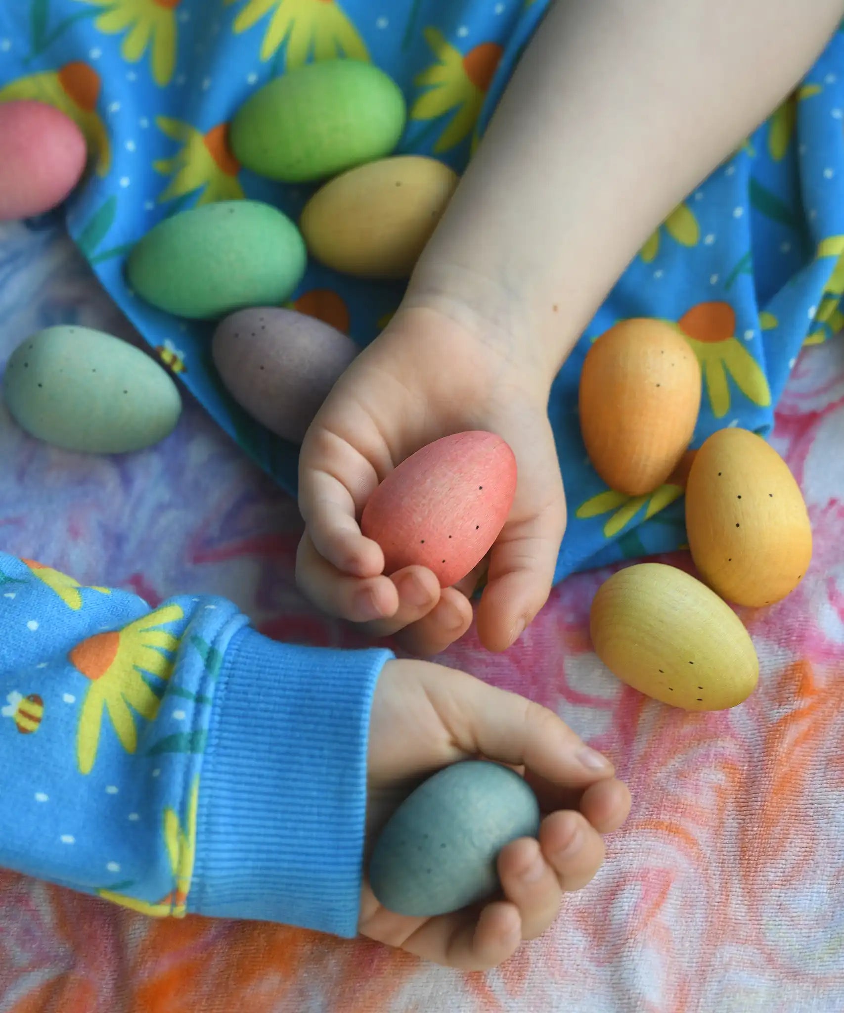 Children's hand picking up Grapat Happy Eggs wooden toys.