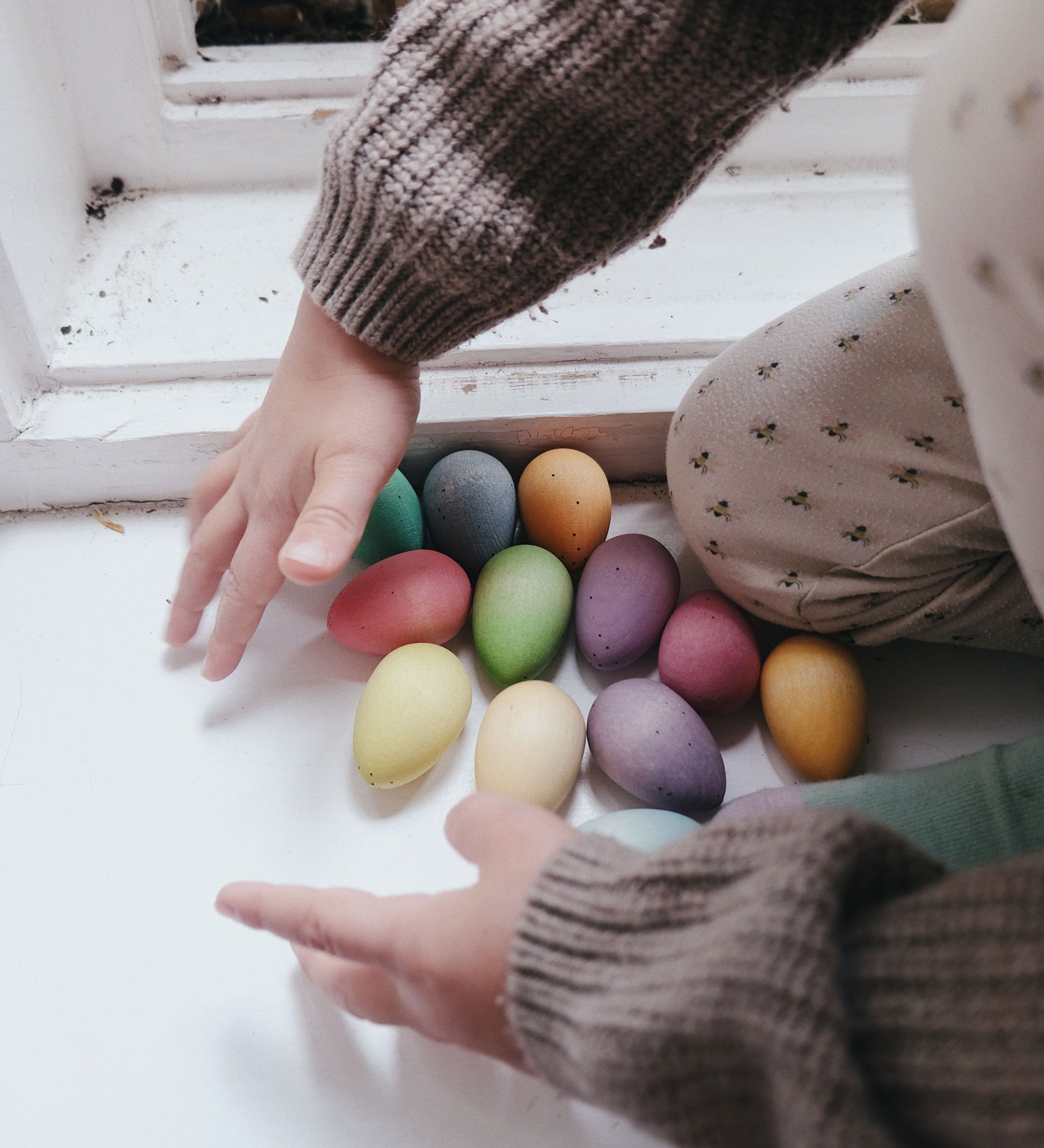 A child collecting the Grapat Happy Eggs Toys together in one pile.