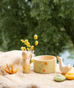 Grapat / Ostheimer Hello Summer wooden figures set showing the peg doll, bowl goose and 2 mandala pieces on a table cloth. 