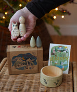 Grapat x Ostheimer Hello Winter limited edition wooden toy play set. An adult's hand is holding the Ostheimer owl and Grapat peg doll. These limited edition sets are available here at Babipur. 