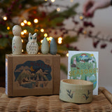 Grapat x Ostheimer Hello Winter limited edition wooden toy play set. The pieces have been placed on a rattan stool. These limited edition sets are available here at Babipur. 