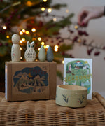 Grapat x Ostheimer Hello Winter limited edition wooden toy play set. The pieces have been placed on a rattan stool. These limited edition sets are available here at Babipur. 