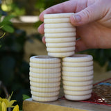 Grapat natural honeycomb cup in an adult's hand.