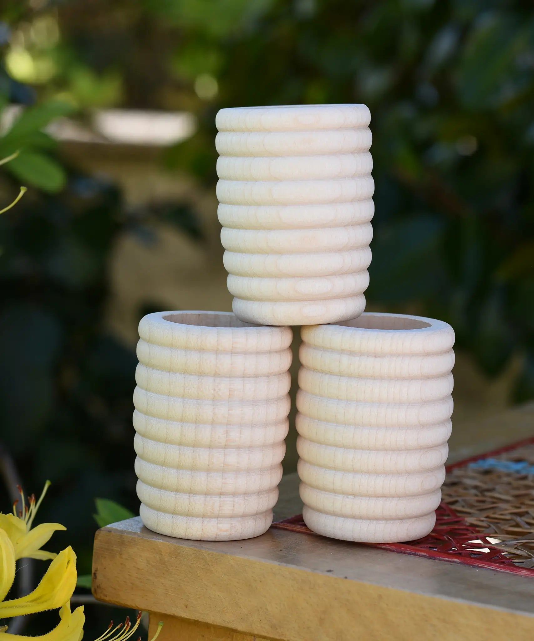 Three Grapat natural honeycomb cups stacked on a stool outdoors in the Babipur garden.