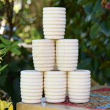 Grapat 6 Natural Honeycomb Cups stacked up on a stool.