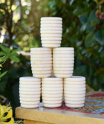 Grapat 6 Natural Honeycomb Cups stacked up on a stool.