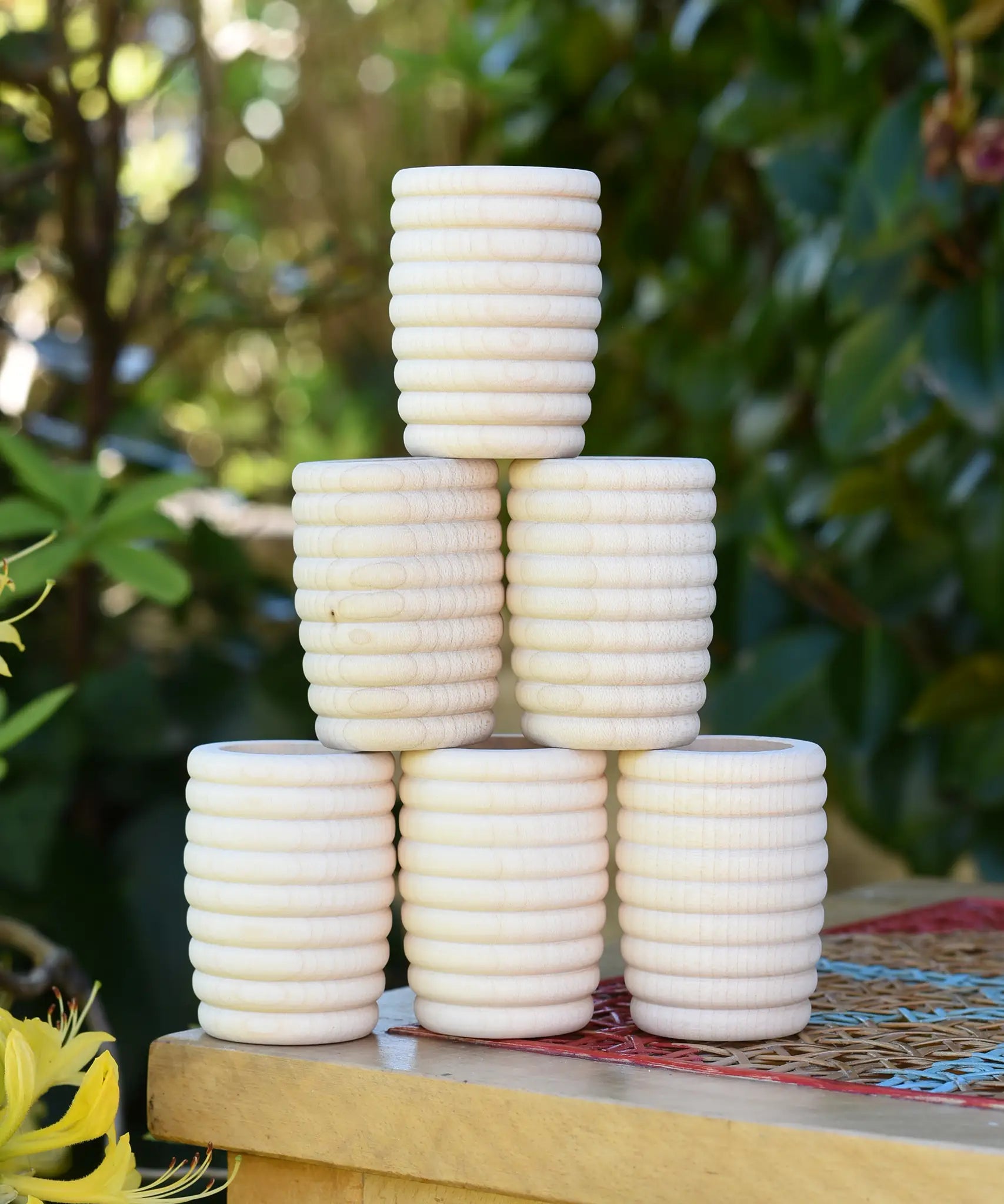 Grapat 6 Natural Honeycomb Cups stacked up on a stool.